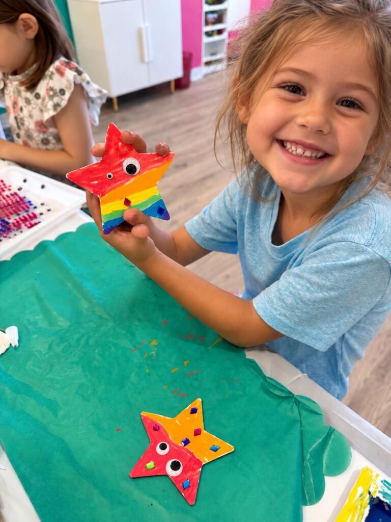 A child creating a colorful star craft at Posh & Pearl Studio